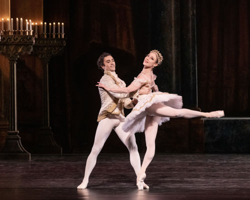 Ballerina på tåspiss med mannlig danser som holder henne