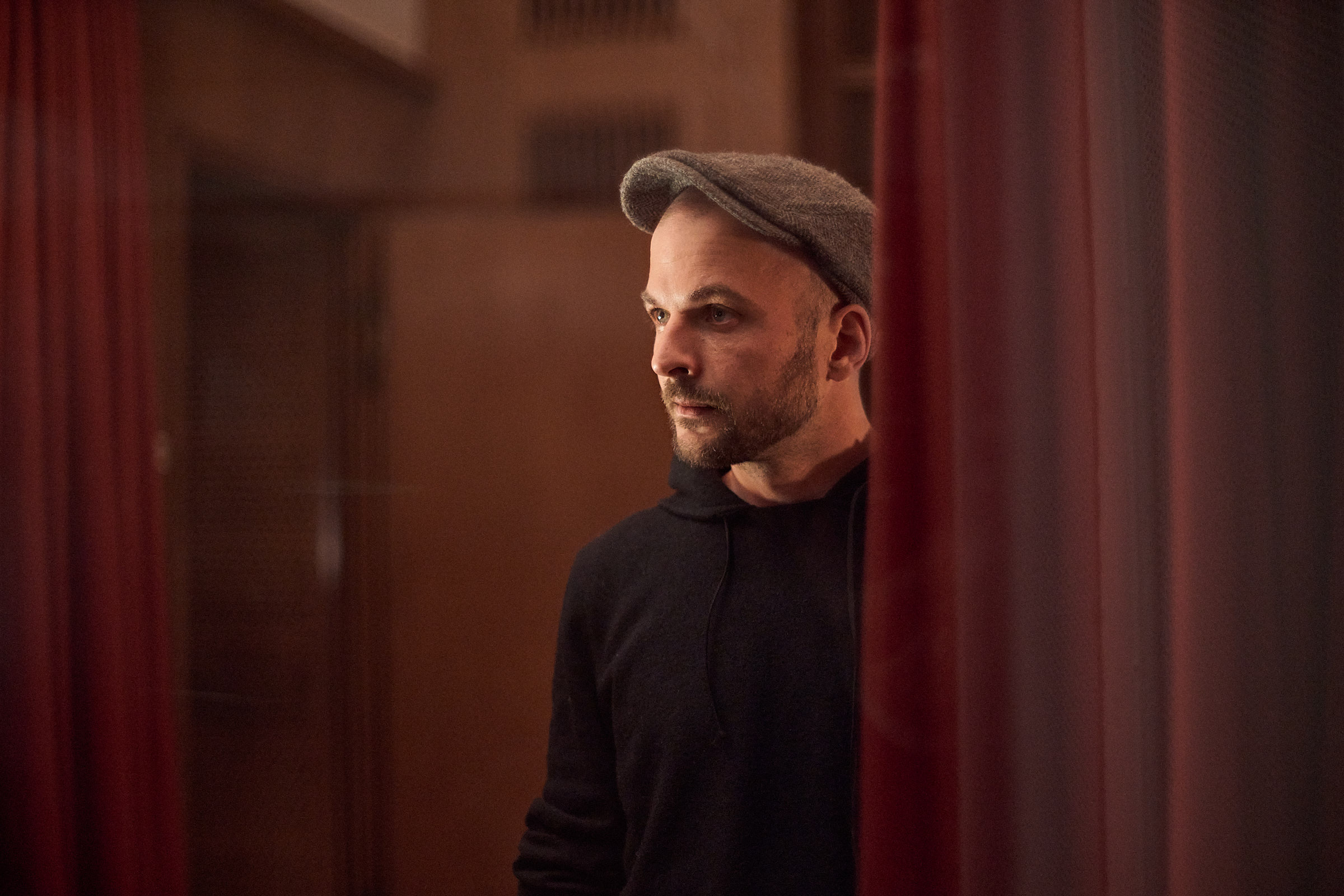 Nils Frahm med sixpence ved siden av tunge gardiner