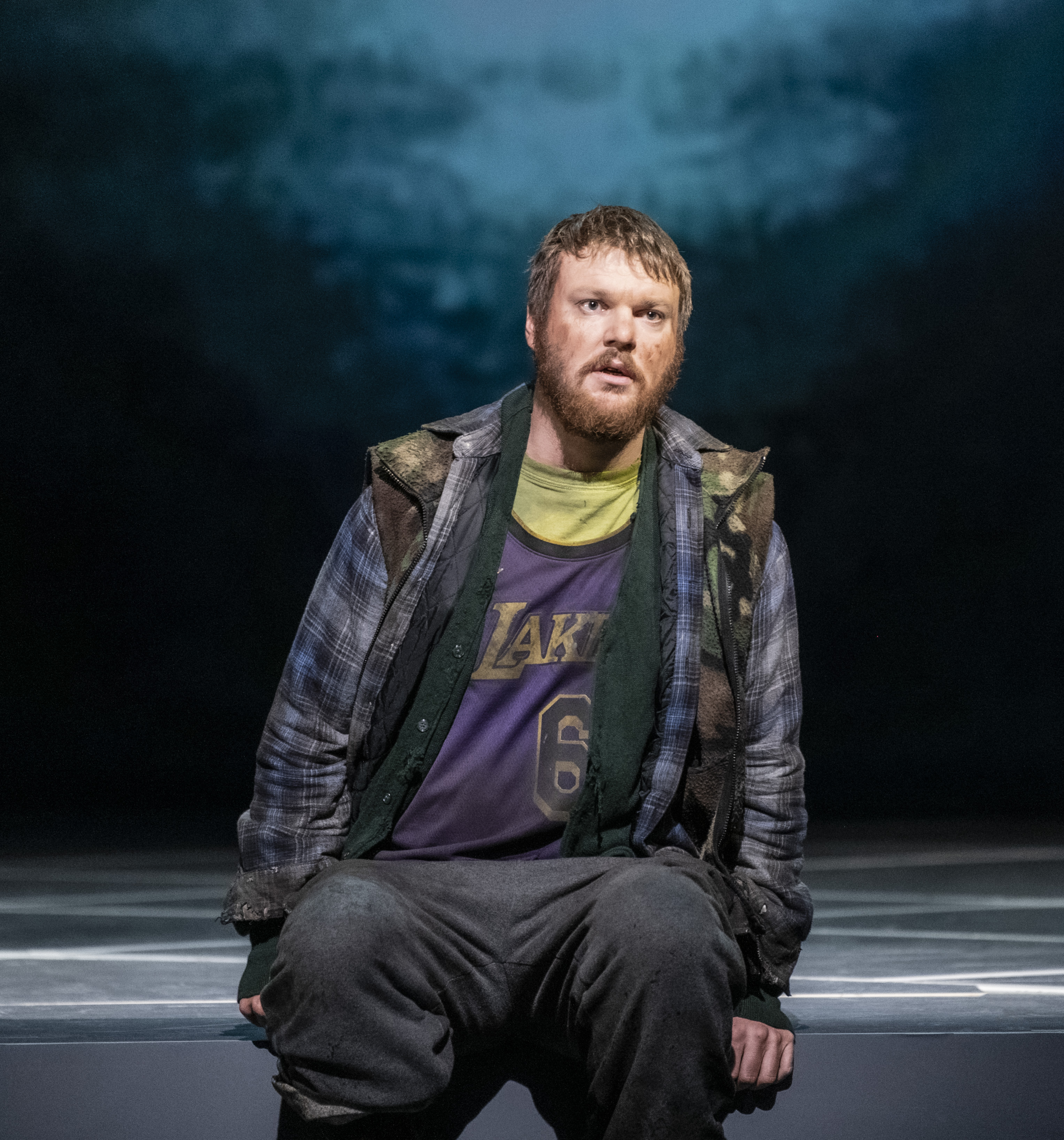 Portrett av alvorlig ung mann som sitter på scenekanten