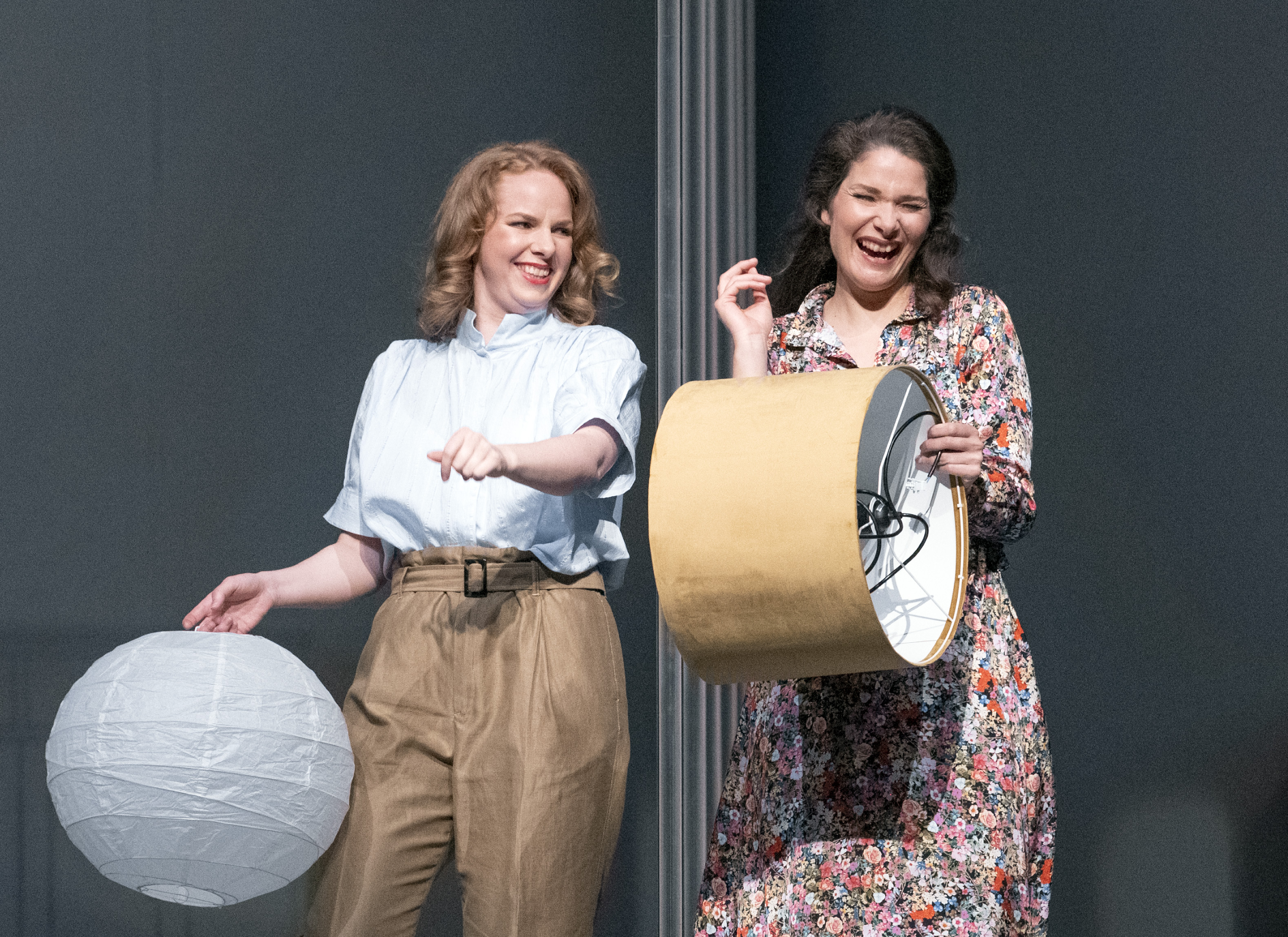 To leende kvinner med lamper i hendene