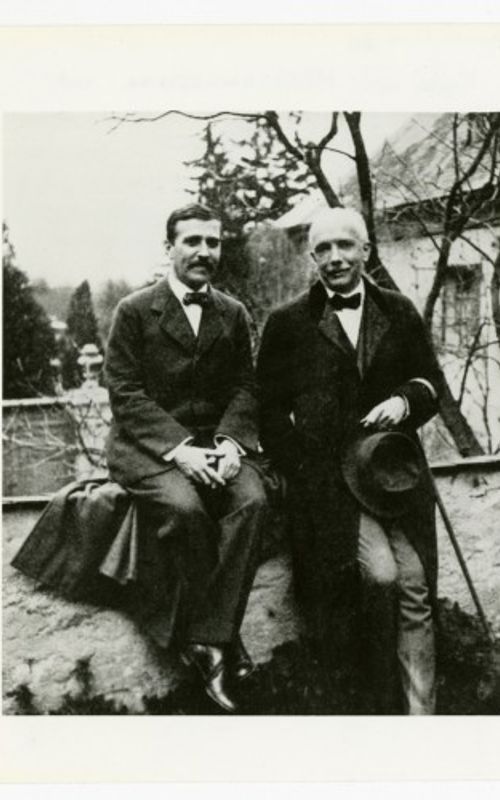 Hofmannsthal og Strauss sitter på en mur