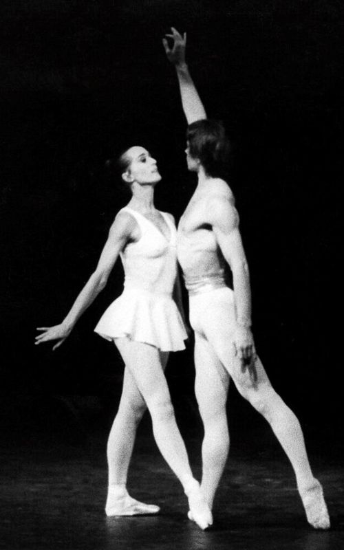 svart hvitt bilde av mann og kvinne som danser i enkle hvite kostymer