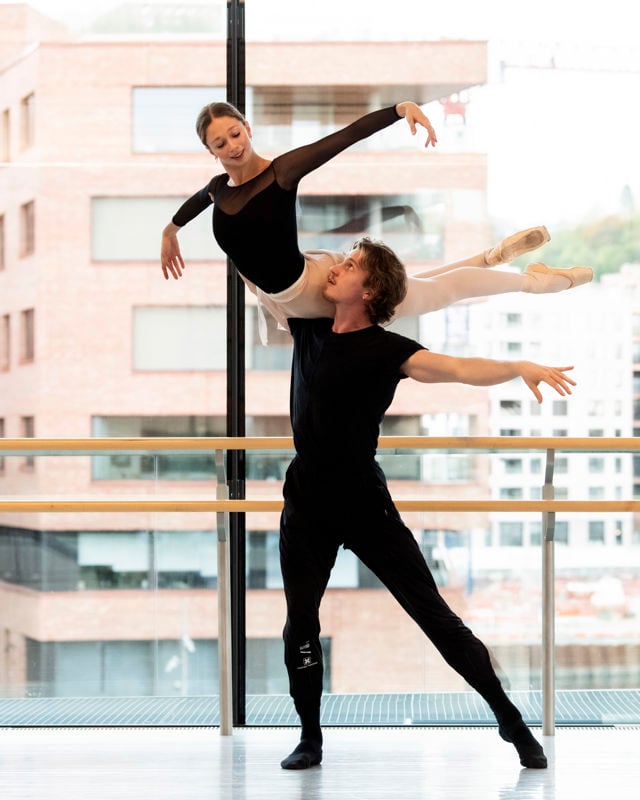 en mannlig danser har løftet kvinnen opp på skulderen
