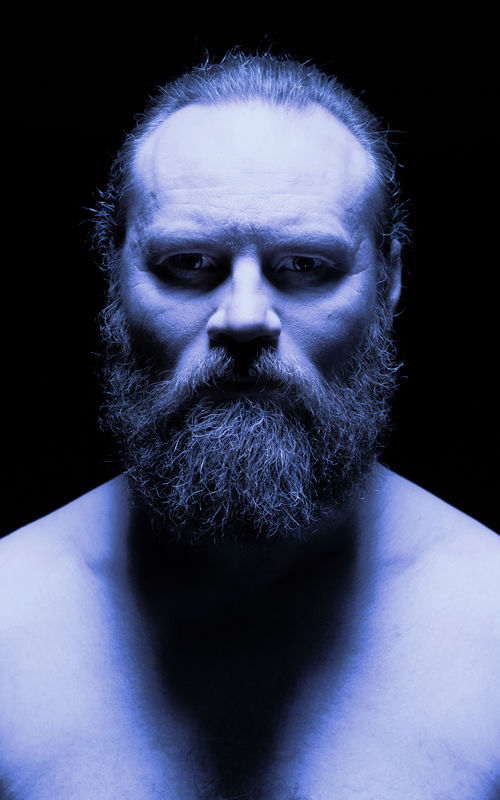 Mann med stort skjegg i blått lys