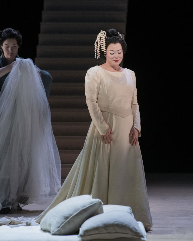 Kvinne i brudekjole, kvinne i bakgrunnen holder slør