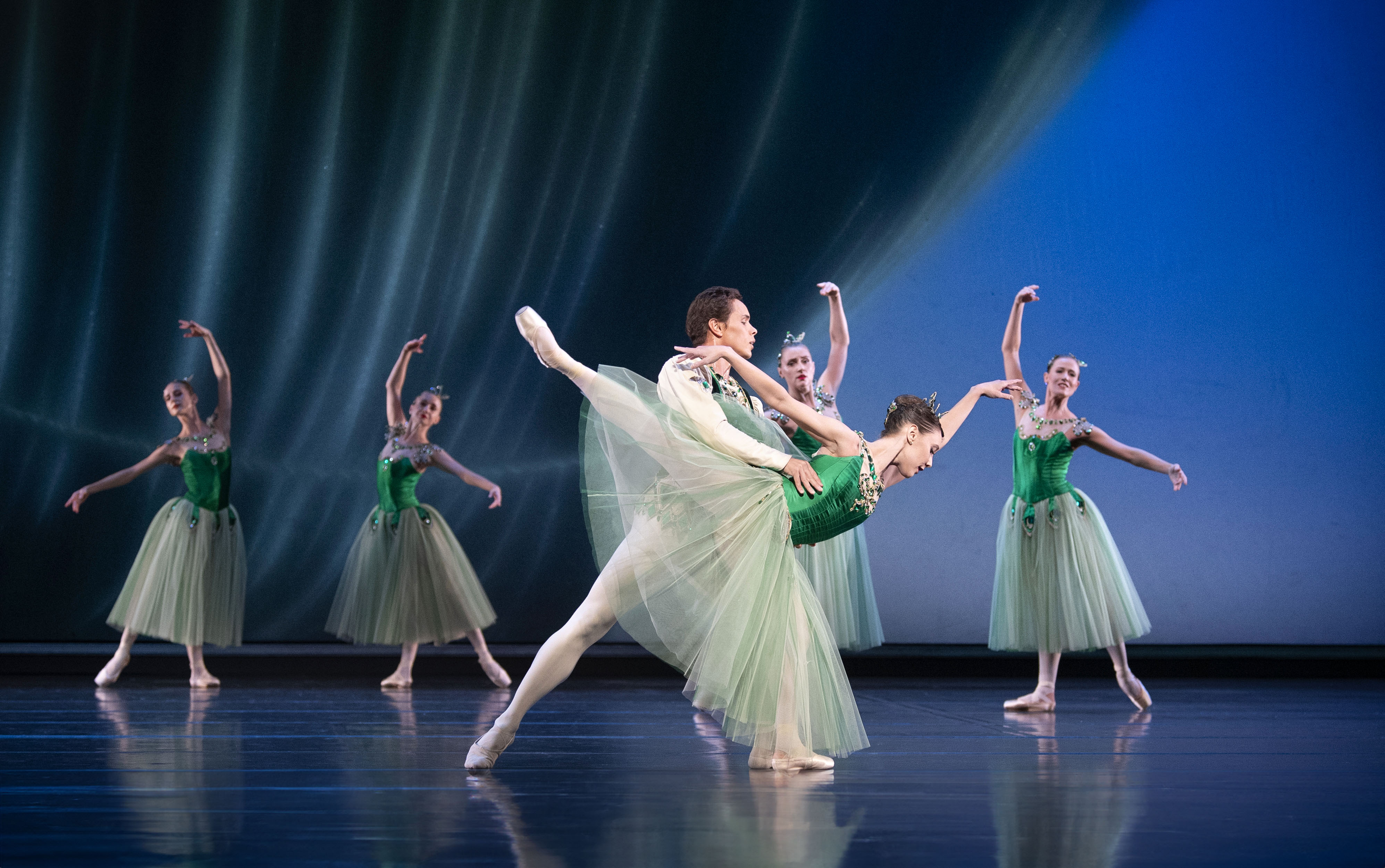 et par danser i grønne kostymer, hun med tåspissko. 4 kvinner i bakkant.