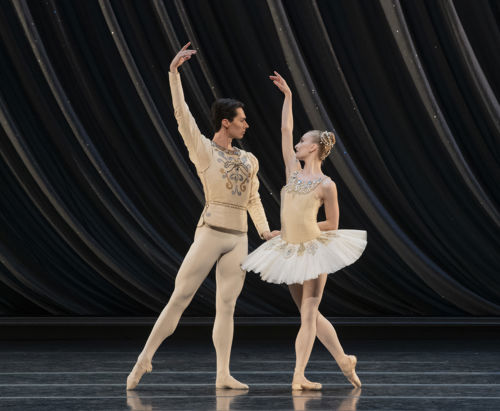 en mann og en dame danser ballett sammen, hun i hvit tutu og tåspissko