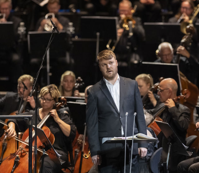 Mann foran orkestermusikere