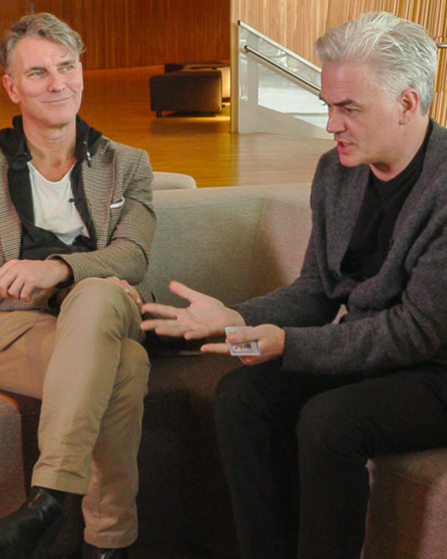 To menn sitter i sofa og snakker sammen