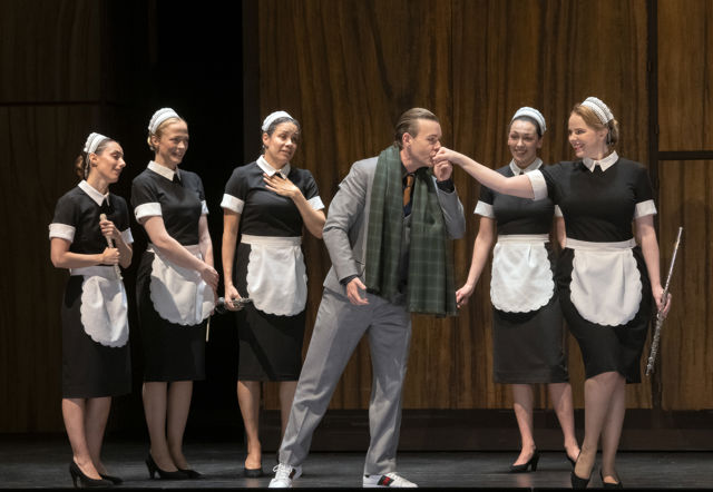 Tjenestepiker ser på at en mann kysser hånden til en av dem