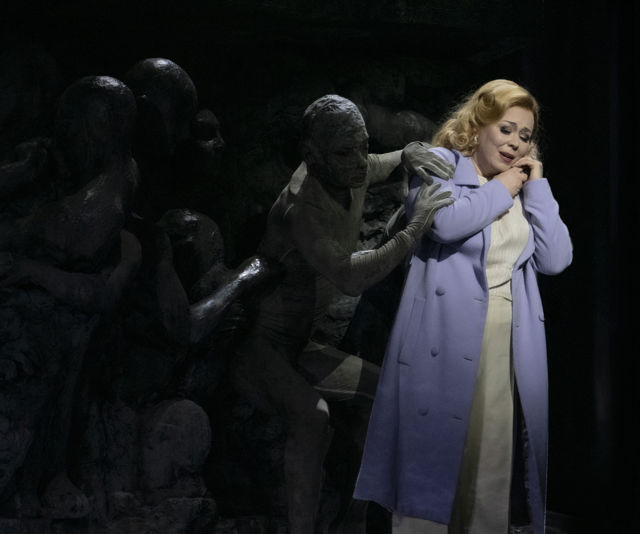 Scenebilde av kvinne i lilla kåpe, omgitt av mørke skikkelser