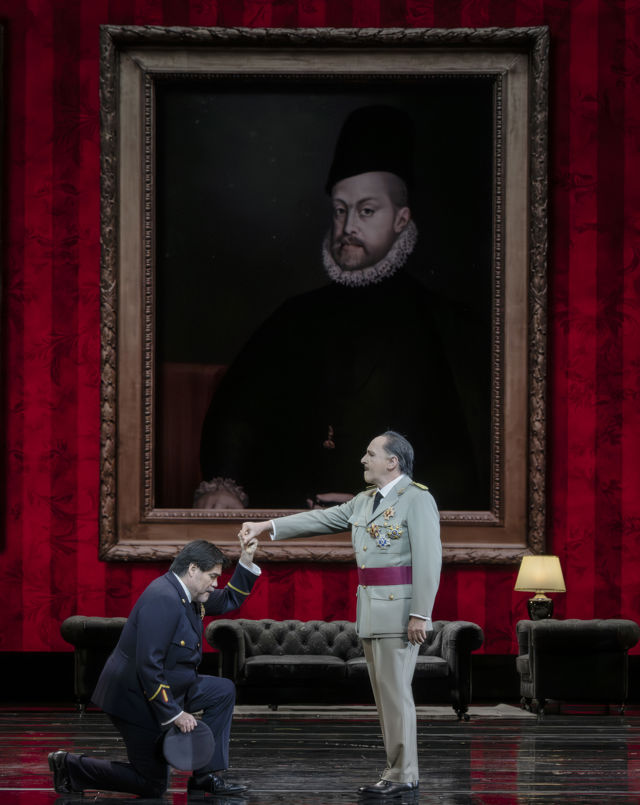 Scenebilde av mann som kneler foran annen mann i militæruniform, maleri i bakgrunnen