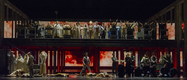 Scenebilde av mange mennesker på gulvet og på et høyere platå bak