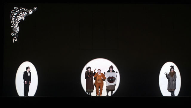 Tre spotlys på flere mennesker i kostymer