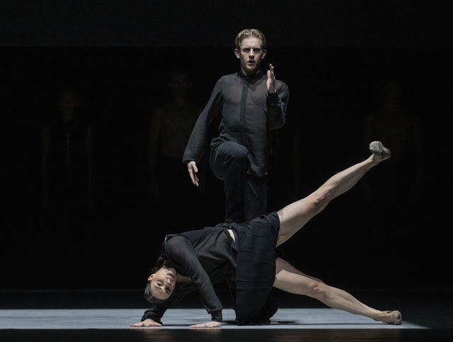 to mørk-kledde dansere på scenen
