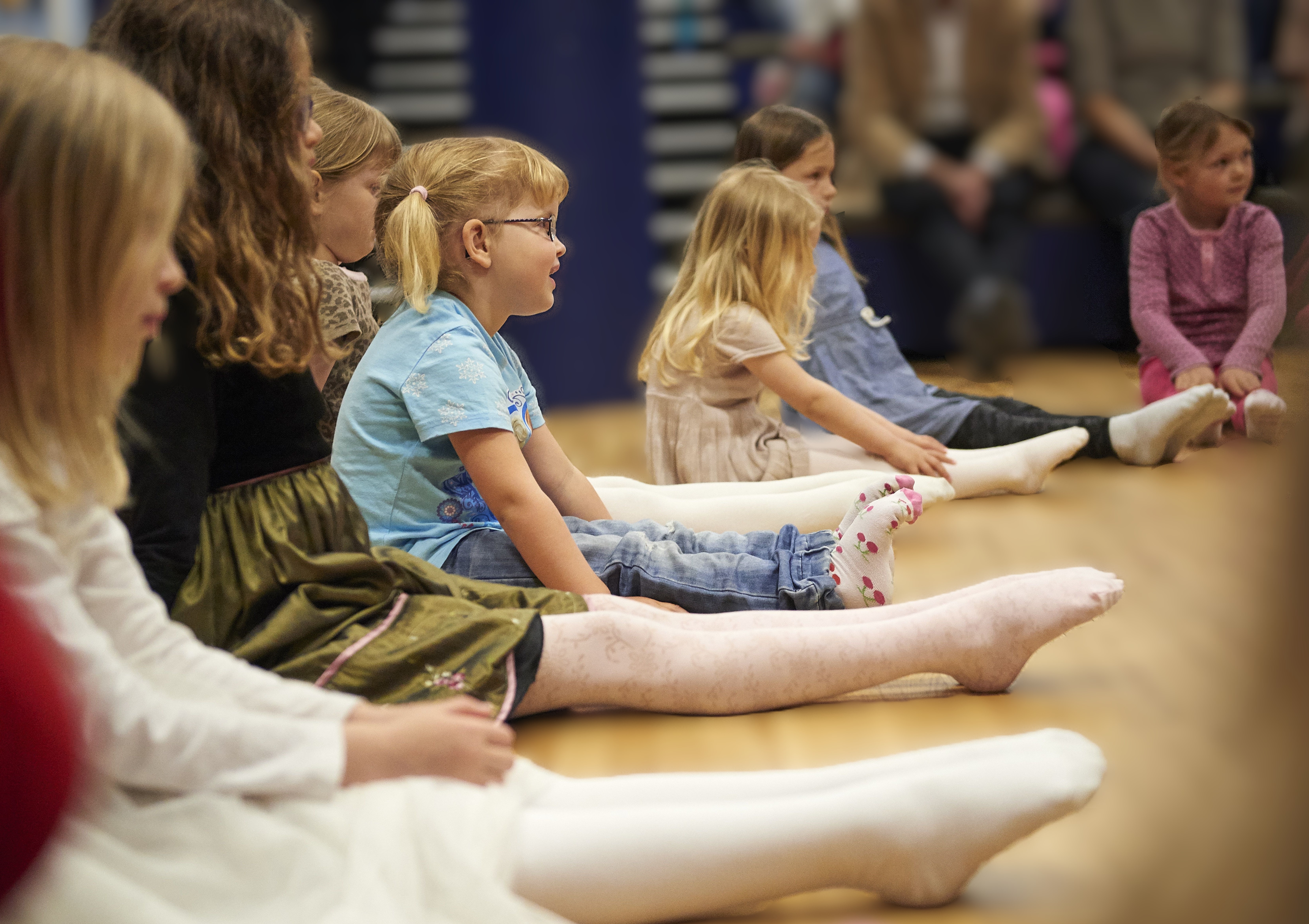 barn som gjør ballettøvelser på gulvet i prøvesalen