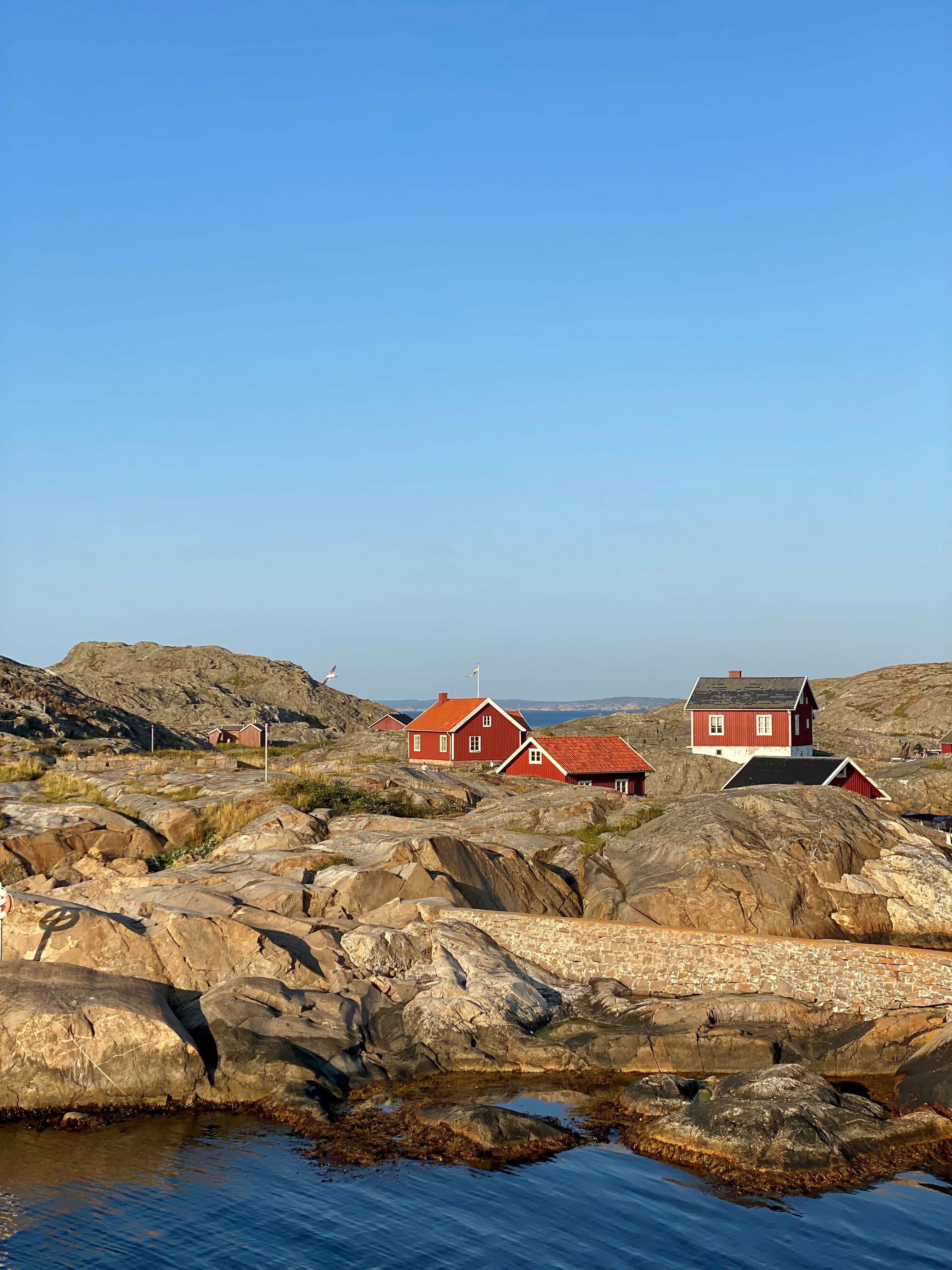 Landskapsbile med sjø, svabarg og røde hytter