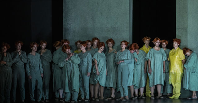Ensemble samlet på scenen foran et grønt scenebilde.